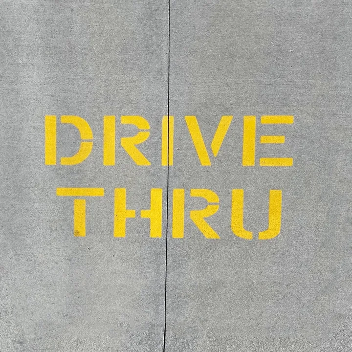 Yellow DRIVE THRU stenciled on pavement at The Mothership