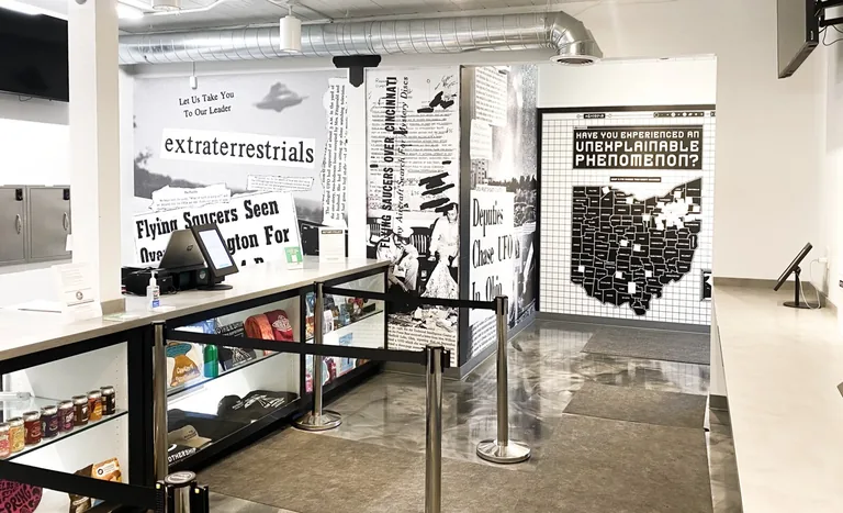 Inside The Mothership Cannabis Dispensary in Streetsboro, Ohio: extraterrestrials mural, retail counter, and Ohio phenomenon map